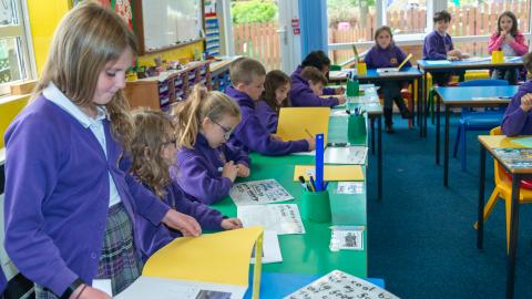 A group of pupils in a classroom setting with their workbooks open