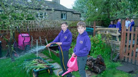 Some boys in the Nature Garden are watering the grass